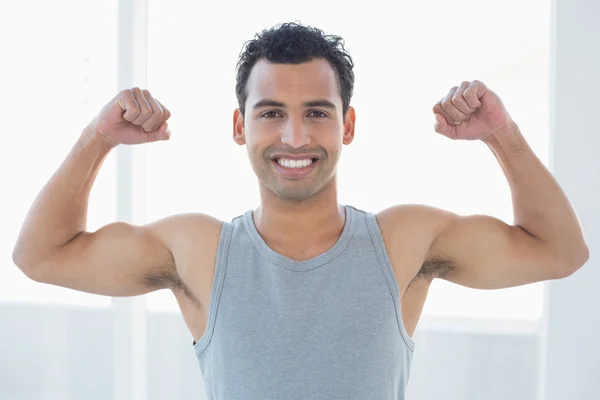 Dopasowanie młody człowiek wyginanie mięśni w fitness studio — Zdjęcie stockowe