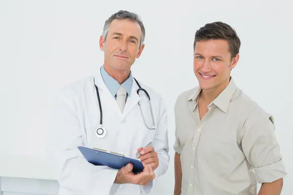 Médico e paciente com relatos em consultório médico — Fotografia de Stock