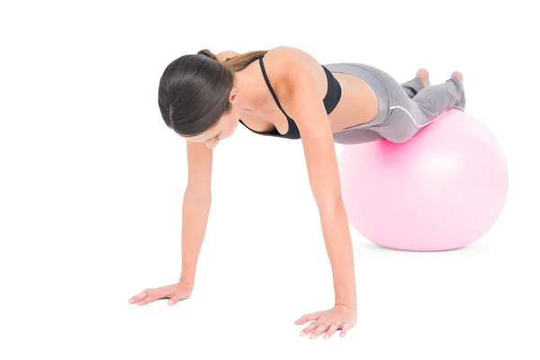 Fit woman doing push ups on fitness ball — Stock fotografie