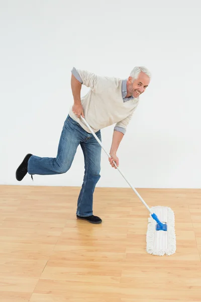Ritratto di un allegro uomo maturo che pulisce il pavimento — Foto Stock