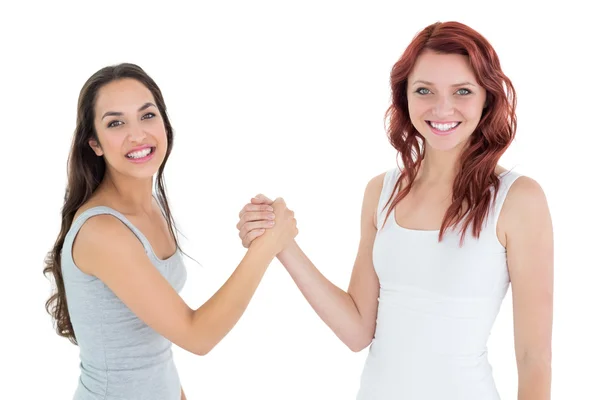 Two cheerful young female friends arm wrestling — Stock Photo, Image