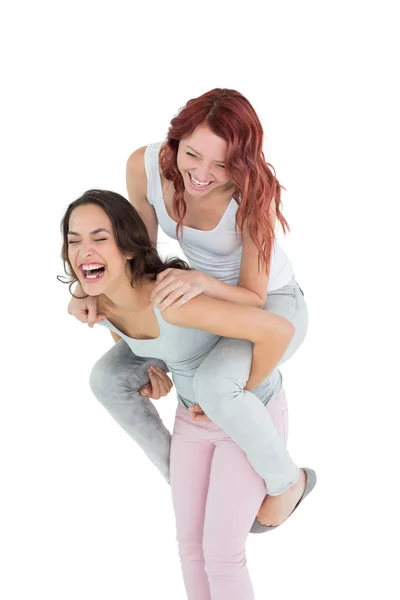 Joyeux jeune femme piggyback heureux ami — Photo
