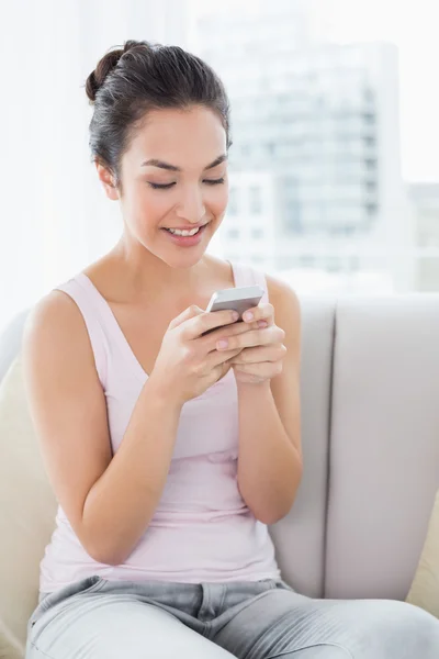 Miłej kobiety SMS na kanapie w domu — Zdjęcie stockowe
