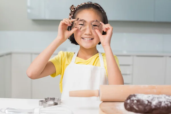 Lachende jong meisje houden cookie mallen in keuken — Stockfoto