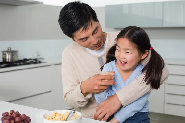 Glad pappa med dotter med spannmål i kök — Stockfoto