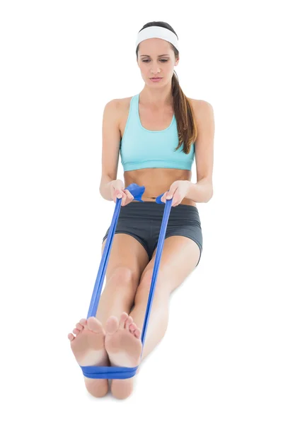 Mujer en forma haciendo ejercicio con un cinturón de yoga azul — Foto de Stock