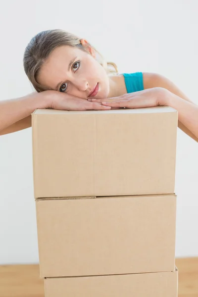 Woman moving in a new house with a stack of boxes — Stock Photo, Image