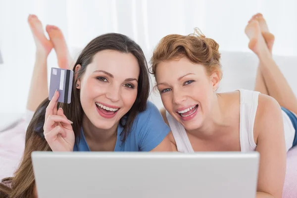 Glad avslappnad vänner gör online shopping i sängen — Stockfoto