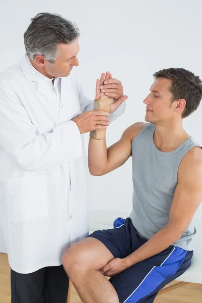 Male doctor examining a patients hand — Stock Photo, Image