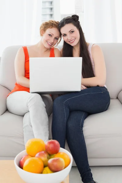 Женщины-друзья используют ноутбук вместе дома — стоковое фото