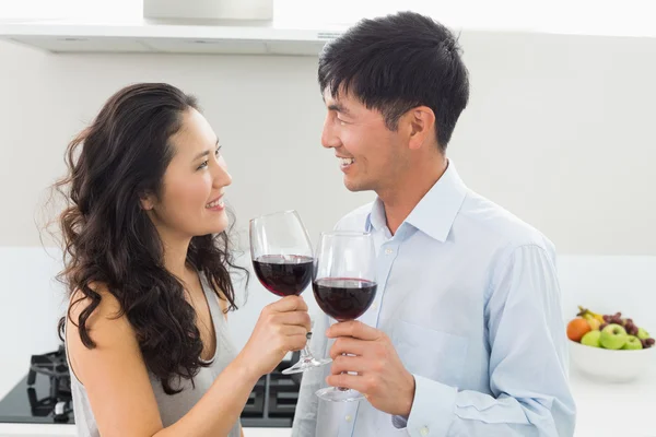 Amar pareja joven con copas de vino en la cocina —  Fotos de Stock