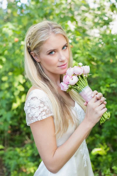 Blond panna młoda, patrząc na kamery przytrzymanie różowy bukiet — Zdjęcie stockowe