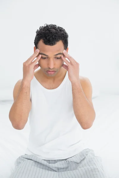 Man lider av huvudvärk i sängen — Stockfoto