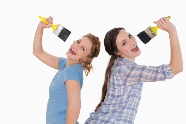 Alegres amigas cantando em pincéis — Fotografia de Stock