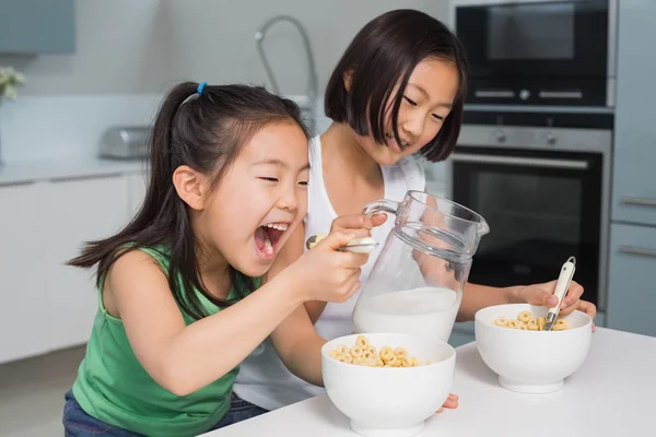 两个快乐的年轻女孩，在厨房里吃谷类食品 — 图库照片