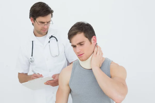 Médico masculino examinando um pescoço de pacientes — Fotografia de Stock