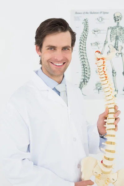 Retrato de un médico varón sonriente con modelo esquelético — Foto de Stock