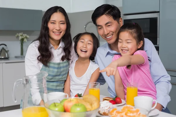 Familia alegre de cuatro personas disfrutando de un desayuno saludable en la cocina — Foto de Stock