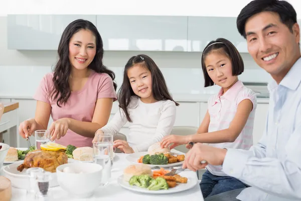 Lycklig familj av fyra njuter hälsosam måltid i köket — Stockfoto