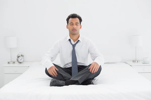 Relaxed well dressed man sitting with eyes closed on bed — Stock Photo, Image