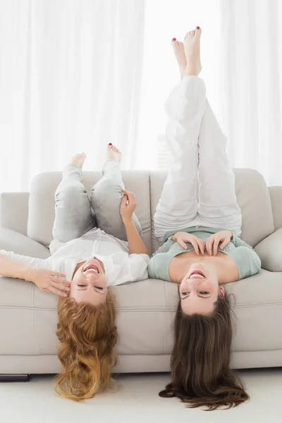 Mujeres amigas tumbadas en el sofá en la sala de estar — Foto de Stock