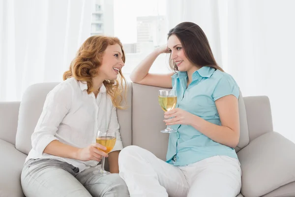 Female friends with wine glasses at home — Stock Photo, Image