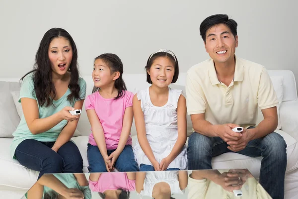 Happy family of four watching tv in living room — Stock Photo, Image