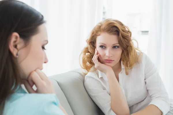 Female friends sitting on sofa in the living room — Stock Photo, Image