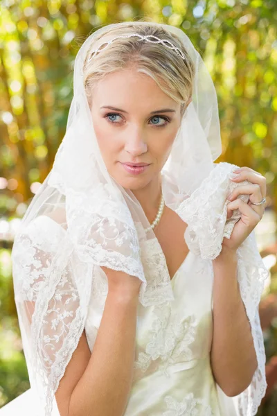 Beautiful blonde bride holding her veil — Stock Photo, Image