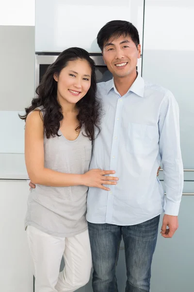 Portrait of a smiling young couple in kitchen — Stock Photo, Image