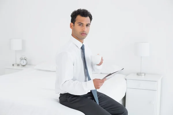 Uomo d'affari con coppa lettura giornale in una camera d'albergo — Foto Stock
