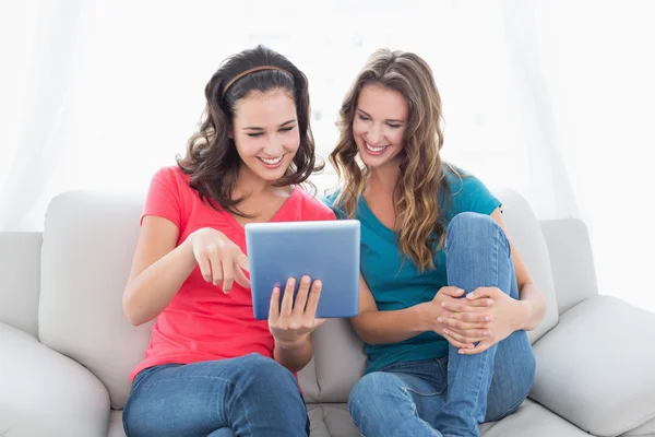 Amici di sesso femminile che utilizzano tablet digitale in soggiorno — Foto Stock