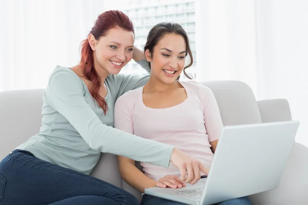 Happy avslappnad kvinnliga vänner använder laptop hemma — Stockfoto