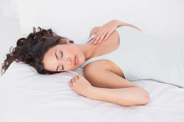 Hübsche junge Frau schläft mit geschlossenen Augen im Bett — Stockfoto