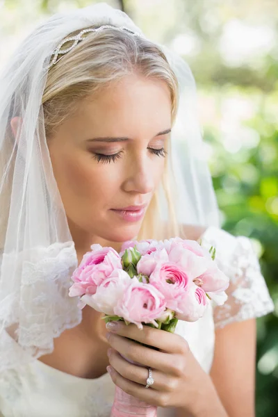 Mariée heureuse dans un voile sentant son bouquet de roses — Photo
