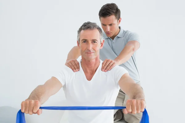 Therapist massaging mans shoulder in gym hospital — Stock Photo, Image