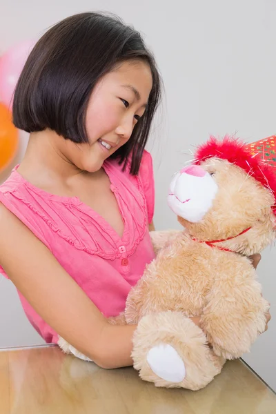 Menina bonito com seu brinquedo macio em uma festa de aniversário — Fotografia de Stock