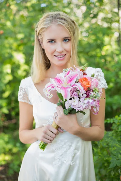 金发碧眼的新娘紧握着大束鲜花，在相机微笑 — 图库照片