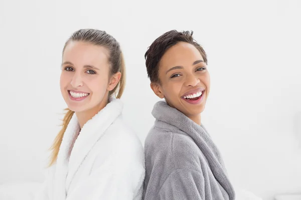 Portrait of two happy female friends in bathrobes — Stock Photo, Image