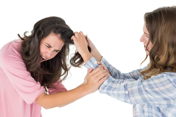 Irritado jovem mulher puxando o cabelo da mulher em uma luta — Fotografia de Stock