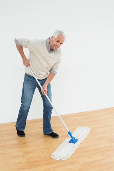 Ritratto a figura intera di un uomo maturo sorridente che pulisce il pavimento — Foto Stock