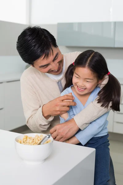 Vrolijke vader en dochter met granen in keuken — Stockfoto