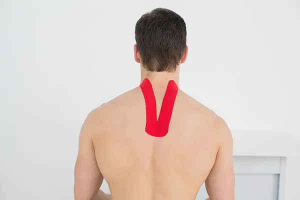 Achteraanzicht van een shirtless man met kinesio tape op rug — Stockfoto