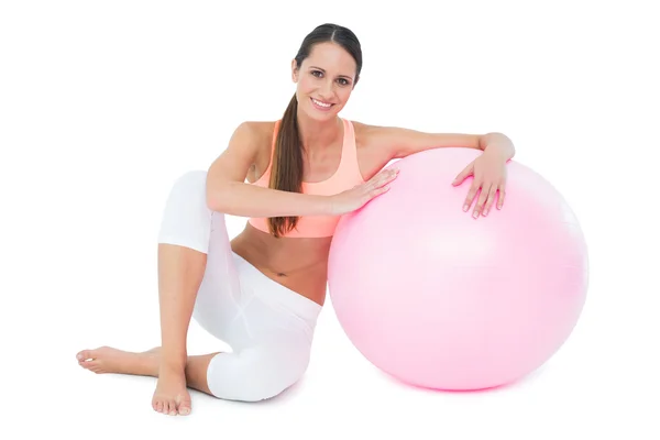 Retrato de una mujer en forma sentada con pelota de fitness —  Fotos de Stock