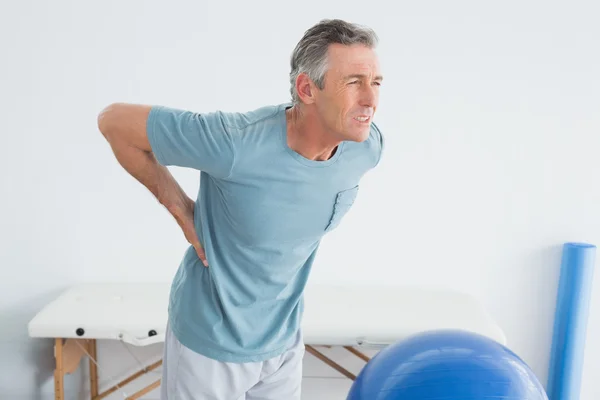 Man with lower back pain at the gym hospital Stock Photo