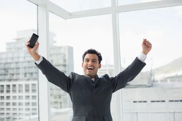 Elegant young businessman cheering in office — Stock Photo, Image