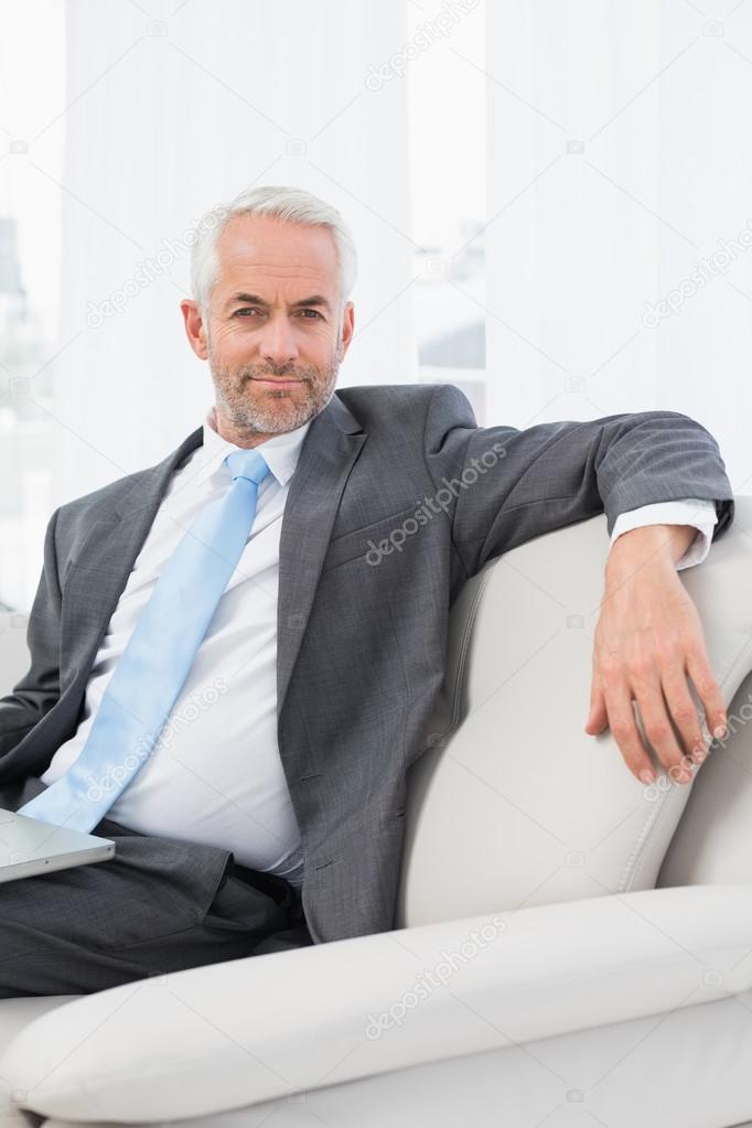 Relaxed mature businessman with laptop at home