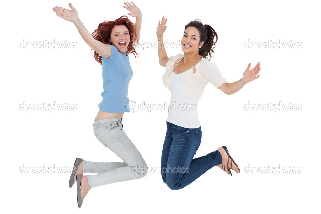 Portrait of two cheerful young female friends jumping