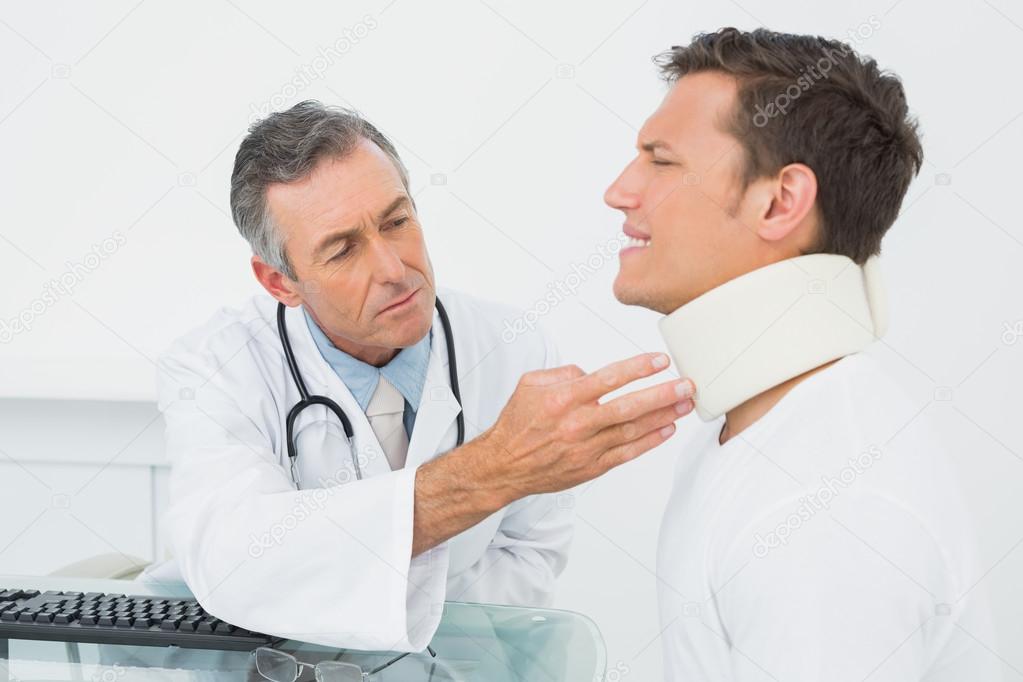 Doctor examining patient at desk in office