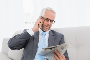 işadamı ile cep telefonu ve evde gazete